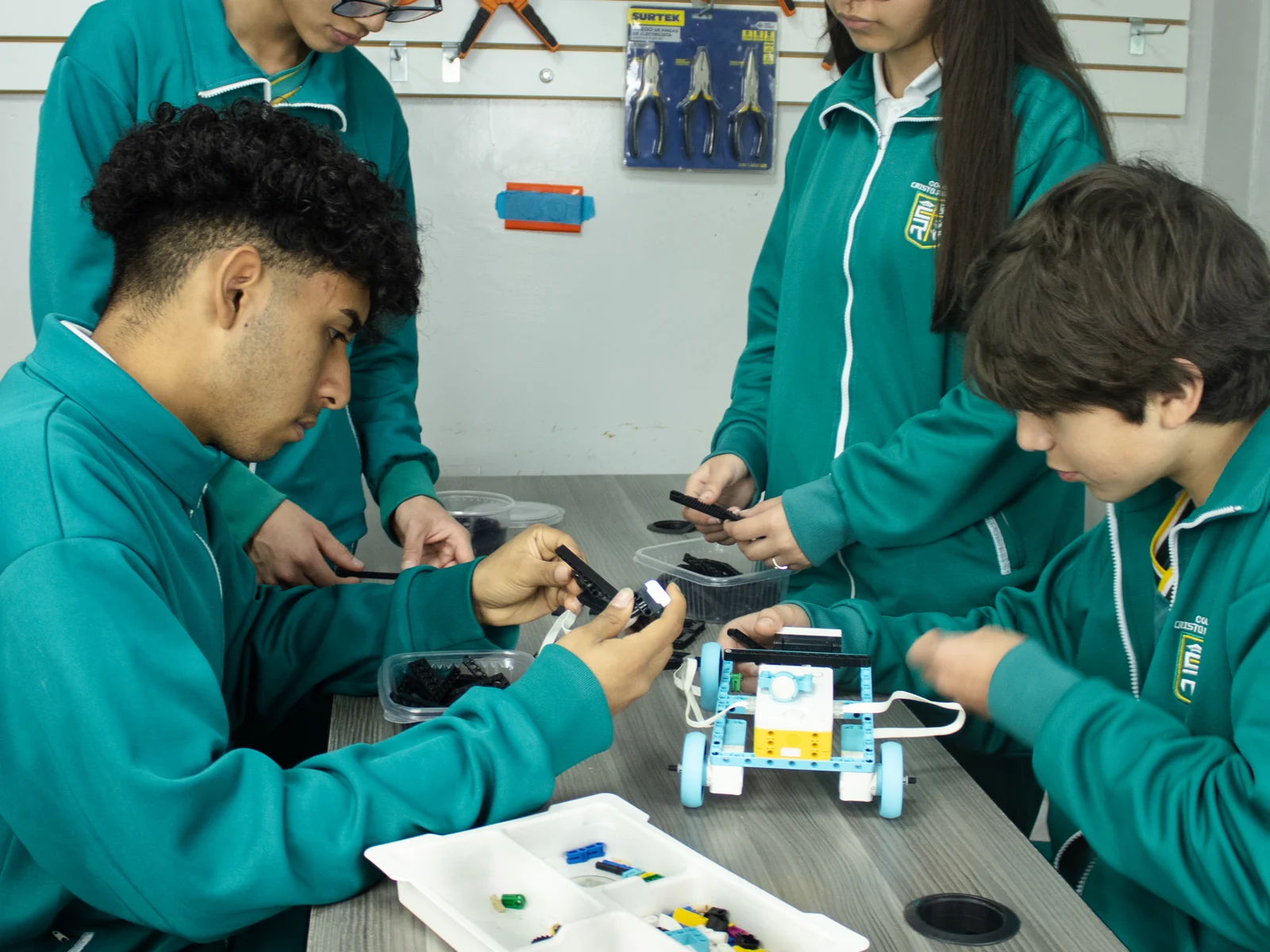 Estudiantes de Secundaria montan un robot sobre la mesa del aula de Ingeniería.