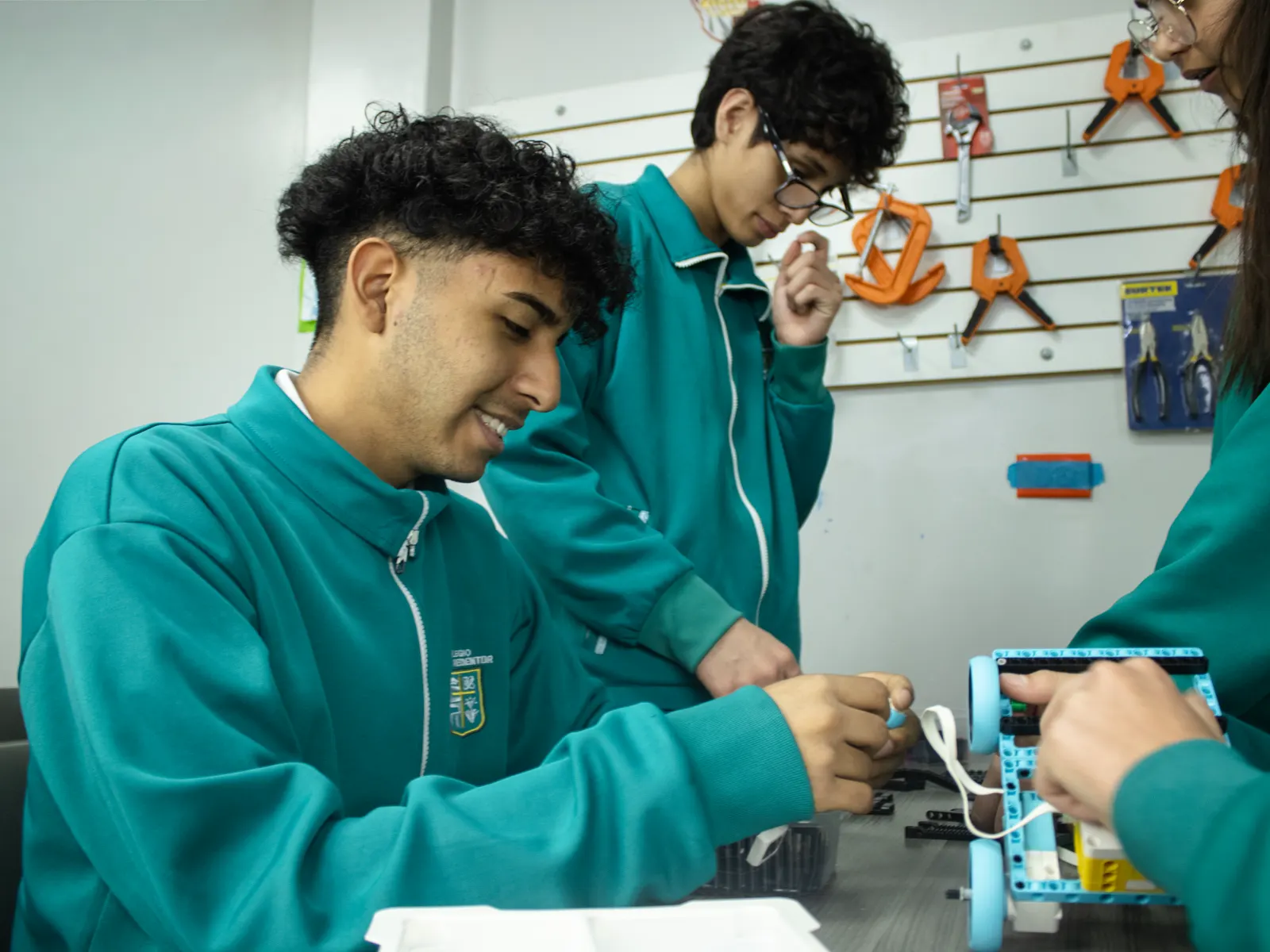 Estudiantes de Secundaria arman un robot con piezas y motores en el taller de tecnología.